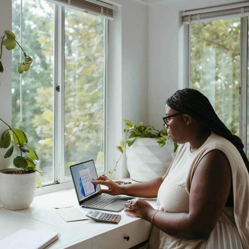 a woman sitting at a table with a laptop