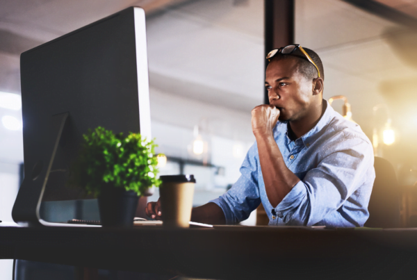 Cropped shot of a handsome young businessman using a computer during a late night in a modern office