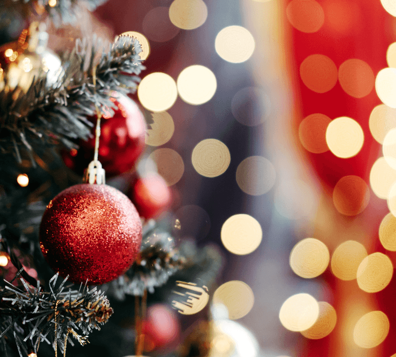 Close up of balls on Christmas tree. Bokeh garland in the background. New Year concept.