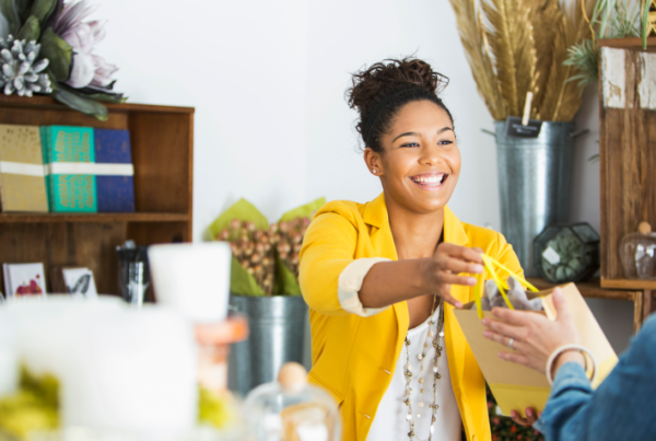 Saleswoman (16-17 years, mixed race African American) helping a customer.