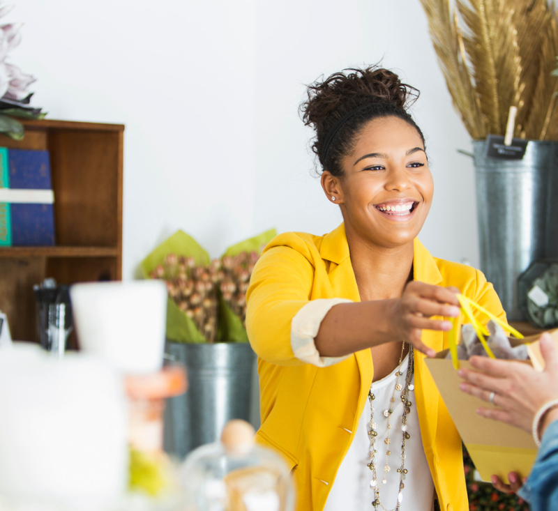 Saleswoman (16-17 years, mixed race African American) helping a customer.