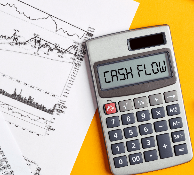 The word cash flow on calculator display screen with business office desktop. To calculate or analyze financial cash flow concept.