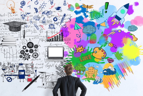 Back view of businessman looking at concrete wall with mathematical formulas and colorful sketch.