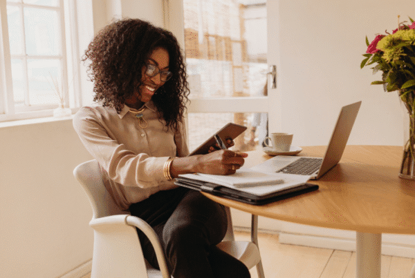Woman entrepreneur managing her business from home working on laptop computer.