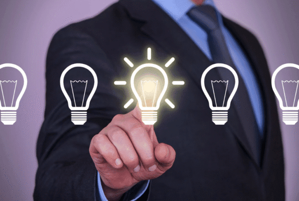 Business professional selecting a glowing lightbulb icon, representing choosing a viable business idea.