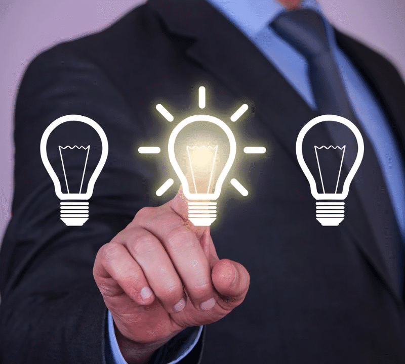 Business professional selecting a glowing lightbulb icon, representing choosing a viable business idea.
