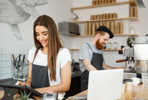 Coffee business Concept – beautiful Caucasian bartender barista or manager posting order in digital menu at a modern coffee shop.