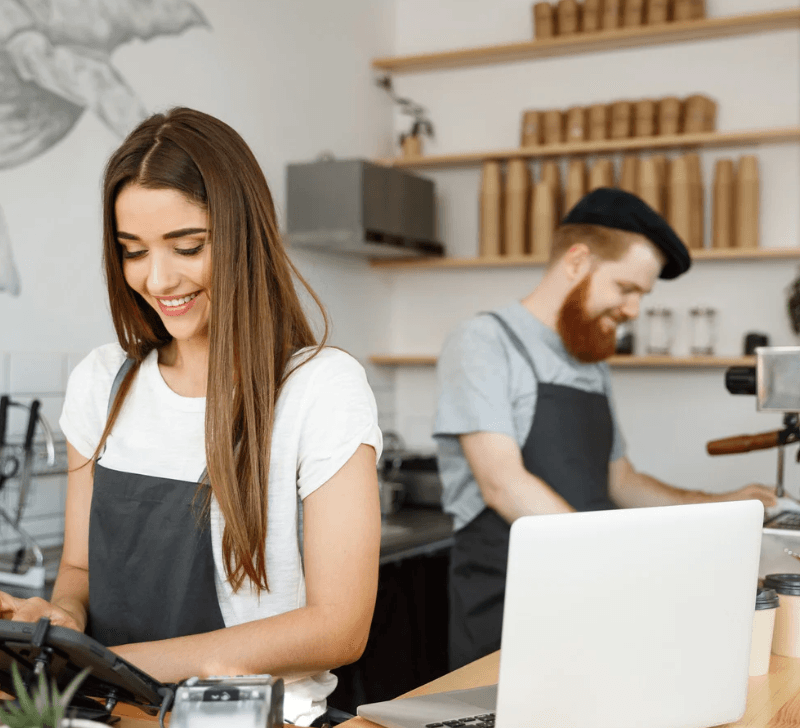 Coffee business Concept – beautiful Caucasian bartender barista or manager posting order in digital menu at a modern coffee shop.