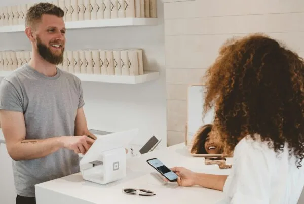 man in grey crew-neck t-shirt smiling to woman on counter