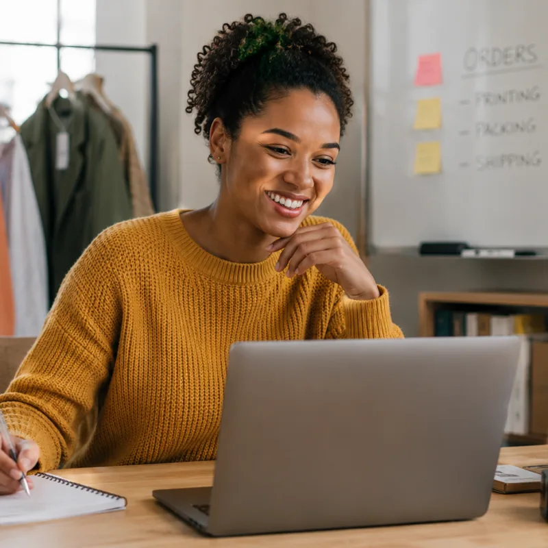 A small business owner works from a home office, assisting customers online while managing orders, showcasing a seamless and customer-focused business experience.
