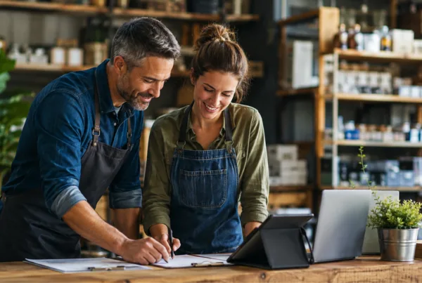 Business owner and employee reviewing workflows to improve business processes.